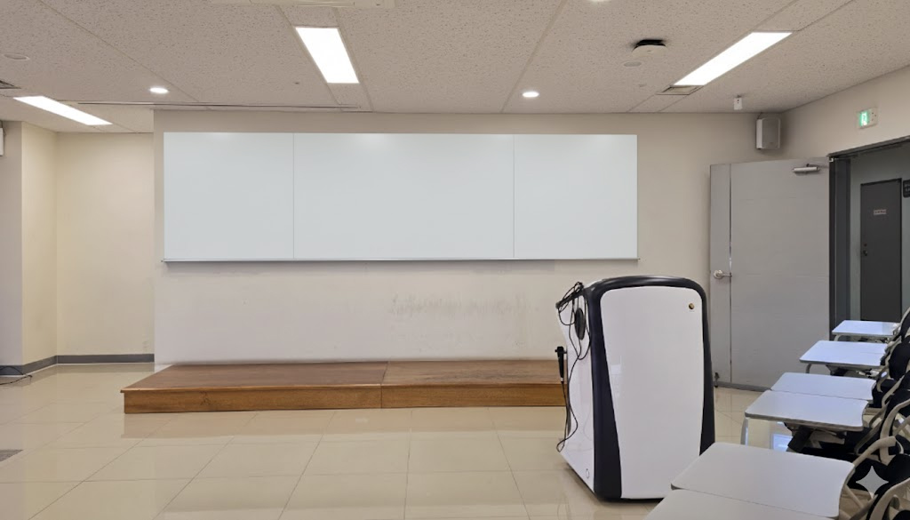 경북대학교 무반사 스크린 유리칠판 3분할 시공 완료 경북대학교 강의실에 설치된 3분할 무반사 스크린 유리칠판. 강연대와 창문이 보임