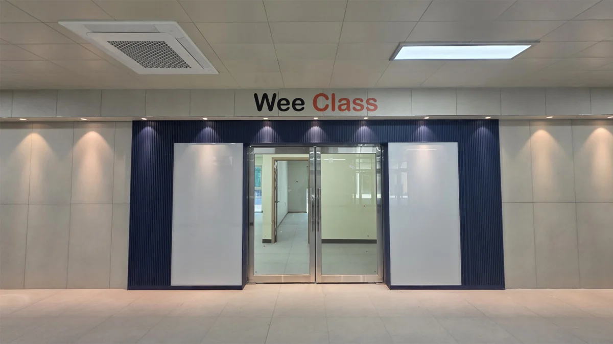 경기예술고등학교 위클래스(Wee Class) 입구 외벽에 깔끔하게 맞춤 시공된 조양글라스의 화이트 백페인트글라스 유리게시판 전면 모습.
