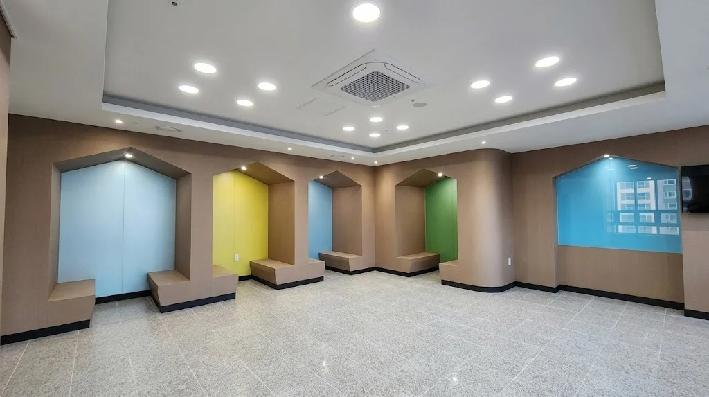 퇴계원중학교 다목적 휴게 공간에 다채로운 컬러의 무광 사틴유리를 집 모양 구조물 내부에 정밀 시공한 전경.