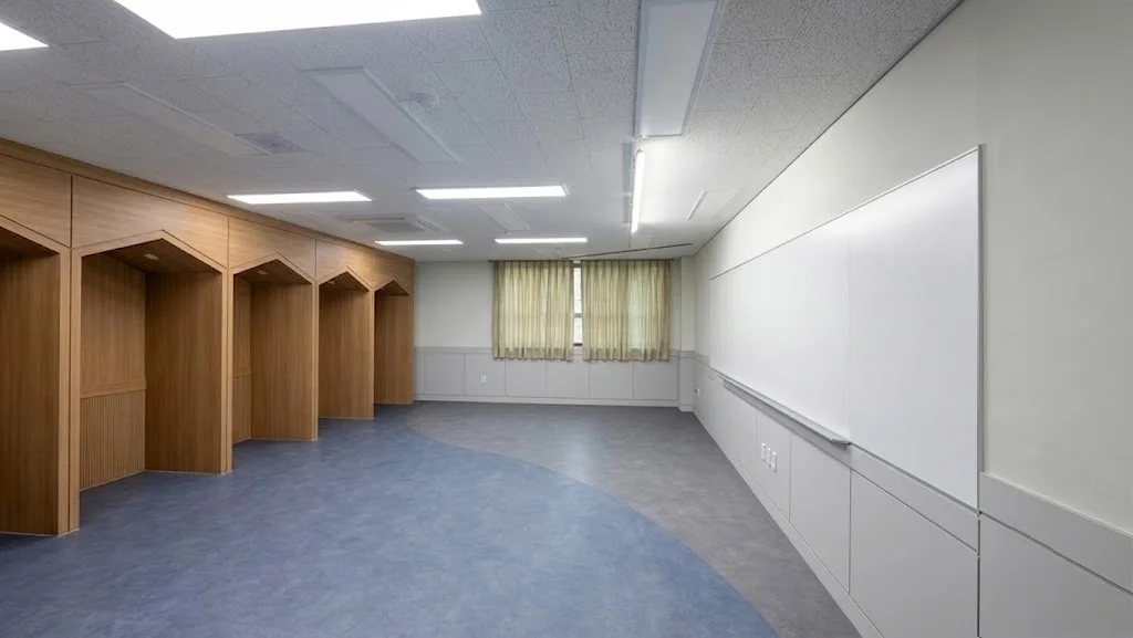 우드톤 인테리어가 돋보이는 교실 벽면에 단차 없이 정밀하게 밀착 시공된 스크린유리칠판 전경