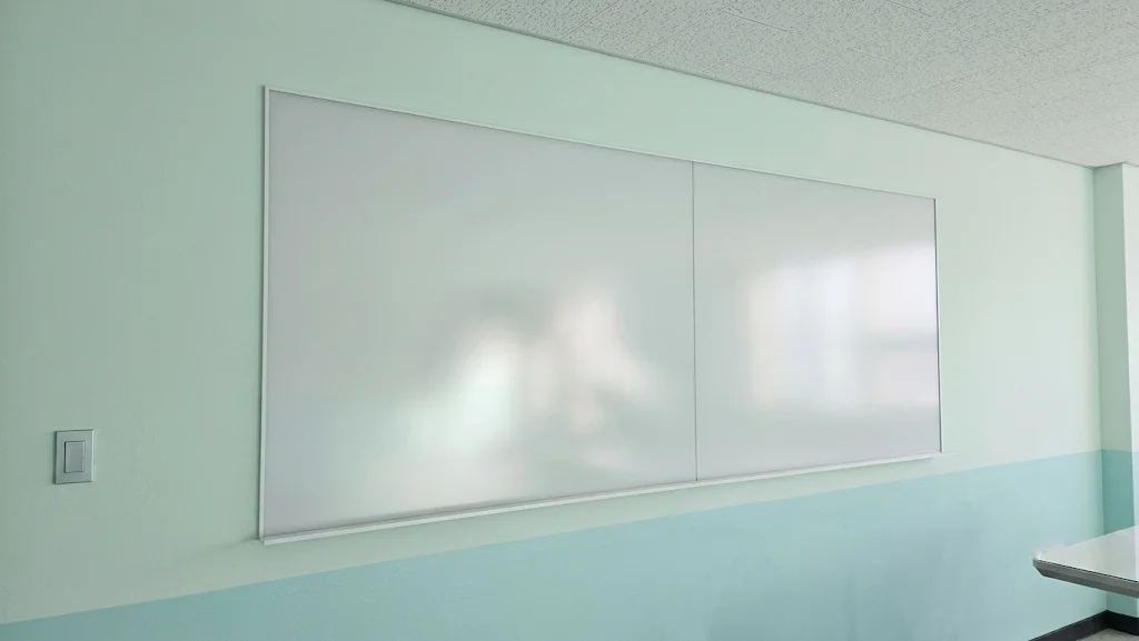 3000x1200mm 사이즈로 교실 벽면에 맞춤 제작되어 우수한 지움성을 자랑하는 반무광 난반사유리칠판.